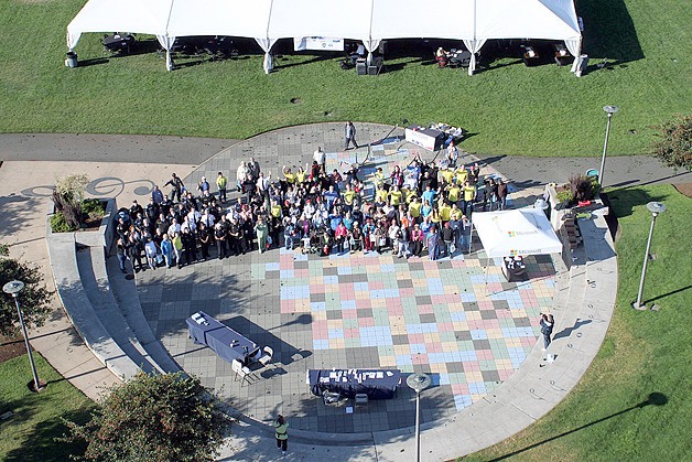A large number of Bellevue seniors smile at a photographer atop a 75-foot ladder Tuesday
