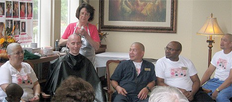 Nancy Chaney (standing) shaves the head of David Standring