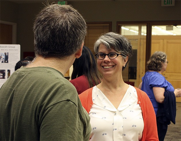 New Interlake High School teacher Beth Gatewood speaks to a researcher during her final presentation for the Science Education Partnership at the Fred Hutchinson Cancer Research Center.