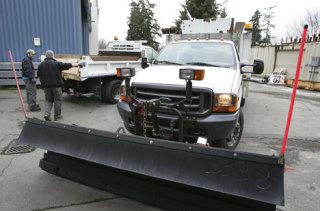 City of Bellevue workers gear up for the possible snowy days ahead as they put snow plow blades on city vehicles Thursday