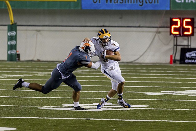 Bellevue quarterback Justus Rogers tries to escape the grasp of Eastside Catholic defensive player Brandon Wellington during the 2014 Class 3A state championship game at the Tacoma Dome.
