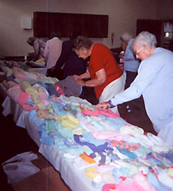 Members of the Stitches From The Heart check over the various knitted items they have made for needy children.