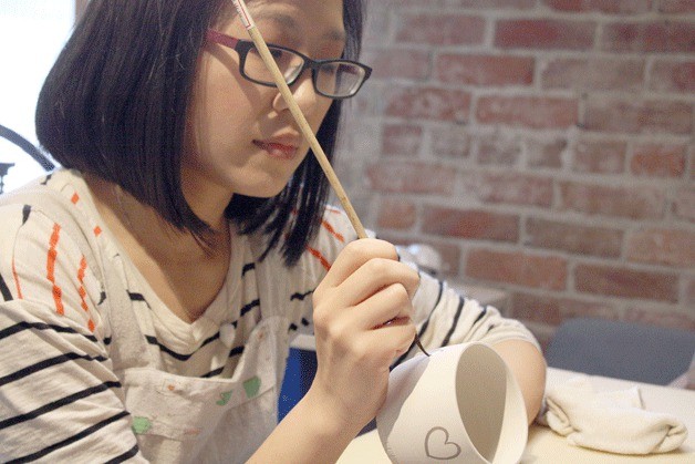 Janice Yu paints a coffee mug at the Kirkland Artist Studio.