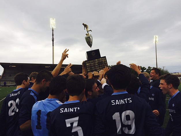 The Interlake Saints boys soccer team hoists the state championship trophy following their 1-0 win against the Mercer Island Islanders in the Class 3A state championship game on May 28 at Sparks Stadium in Puyallup.