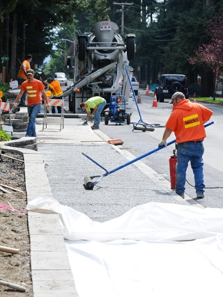 Workers pour and finish a section of permeable sidewalk near Ivanhoe Park on Friday