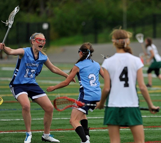 Joanna Heywood (#17 blue) celebrates with Camille Sullivan (#2 blue) following Sullivan’s game winner with 7 seconds remaining in overtime to give Bellevue East their first state championship with a 17 – 16 defeat of Overlake