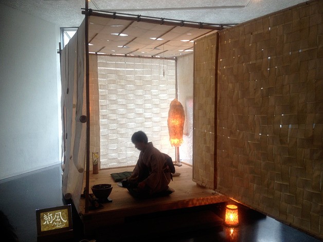 A woman carefully cleans away all the utensils after preparing a cup of green tea for guests