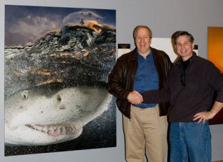 Bruce Yates (left) stands next to his photo of a smiling shark as Steve Freligh