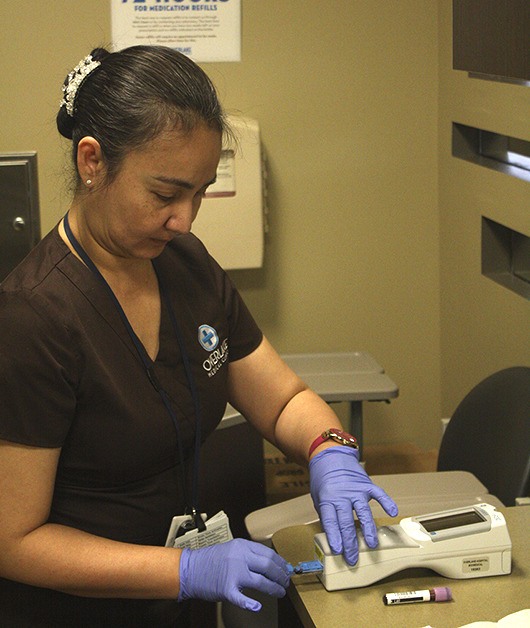 Overlake registered nurse Zarmi Marasigan processes a blood test at the new urgent care center on Tuesday