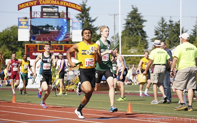 Bellevue junior Isaiah Gilchrist carries the baton down the home stretch in the Class 3A 1600-meter relay finals. The Wolverines captured first place in the event with a time of 3:22.69.