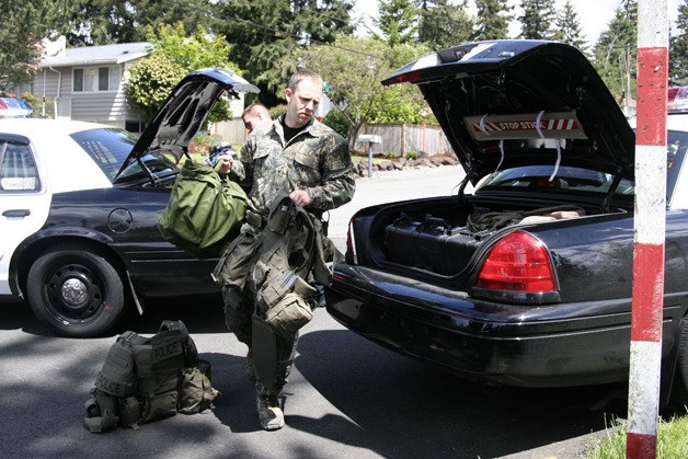 A Bellevue officer begins suiting up for the SWAT Team that helped bring a 75-year-old man into custody after a 2-hour standoff Thursday