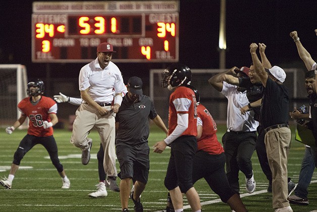 Sammamish Totems football head coach Michael Cooke (Sammamish hat) celebrates after his team ties the game at 34-34 against Chief Sealth on Sept. 16 in Bellevue. Sammamish defeated Chief Sealth 40-34 in overtime.
