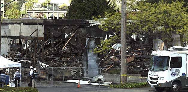 Crews work to clear the debris left after the AutoNation Ford dealership burned down on April 25. The cause is undetermined