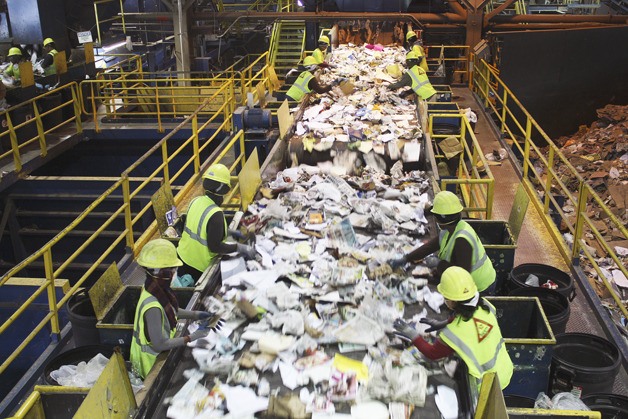 Workers move at high speed to remove materials such as textiles that could harm the equipment at the Material Recovery Facility.