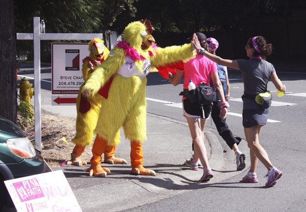 Ashlee McKenney and Kim Faretra in chicken costumes support walkers as they approach Grass Lawn Park in Redmond.
