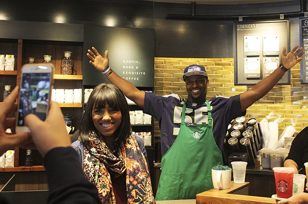 Seahawks defensive end Cliff Avril poses with a fan while “working” at the Starbucks on Northeast Eighth Street in Bellevue on Sept. 22.