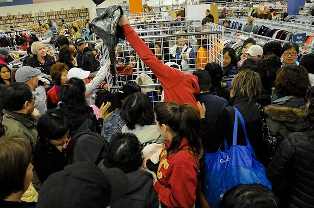 Bargain hunters scramble to comb the racks during the designer label sale at the Goodwill in Bellevue on Friday.