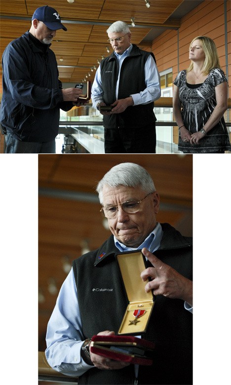 Top: Bellevue police Det. Dan Mathieu prepares to hand over items that burglars stole from the homes of Bill Plummer and Suzanne Yu. Plummer recovered his father's Bronze Star and Yu regained her grandmother's wedding ring during an event at Bellevue City Hall. Bottom: Bill Plummer shows off the Bronze Star his father earned during World War II.