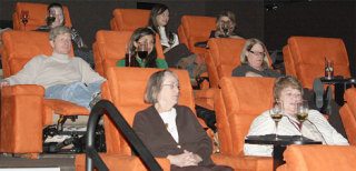 Patrons at the Gold Class Cinemas in Redmond relax with wine and upscale food in side-by-side recliners. Oh