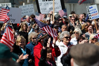 Demonstrators rally at Bellevue City Hall to raise awareness about federal tax policies on Wednesday