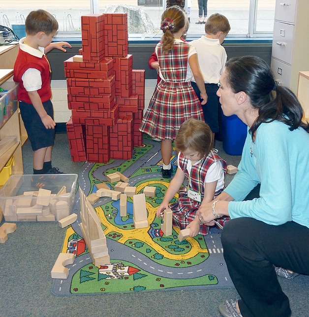 Teacher Karen Salmon works with students and blocks.
