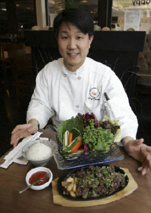Asian Spoon’s chef Steven Jun poses with several dishes served at the restaurant.