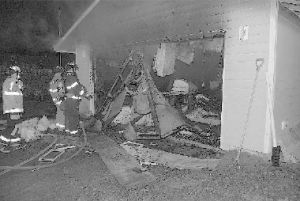Firefighters check out the damage to a garage fire in Bellevue Tuesday.