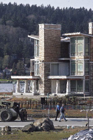 Construction workers walk past one of the luxury homes under construction at Barbee Mill on the shores of Lake Washington just south of Bellevue.