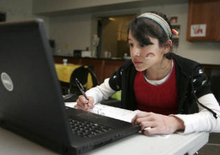 Maria Alejandra Flores Cardenas does homework during a kids after school program at Jubilee Reach Center on Wednesday