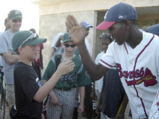 Jorn Peterson learns the Dominican game from local player as Craig Peterson and Arthur McCray look on.