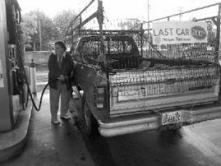 Ronnie Short fills up her truck as the last customer to receive free gasoline from the Washington State Lottery on Friday morning. Her Dodge truck sported the sign that signaled to other motorists that she was the last of the 200 eligible customers to receive the free fuel.