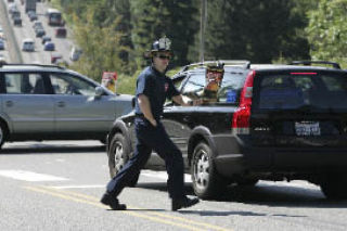 Firefighter Will Dume stands on the corner of 84th Avenue Northeast and Northeast 28th Street in Clyde Hill collecting money for the Muscular Dystrophy Association as part of the annual ‘Fill the Boot’ day on Friday
