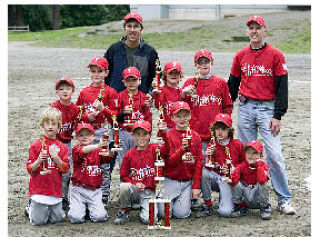 Members of the Phillies of the Bellevue Thunderbird machine-pitch Little League team pose with their coaches and trophy at the end of their undefeated season. Front row
