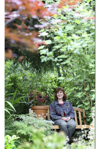 Sharon Rodman sits among the wildlife habitat she has created in her backyard. The habitat will be part of the Symphony of Gardens Tour