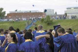 Bellevue High School students celebrate their graduation by throwing their motar boards into the air.