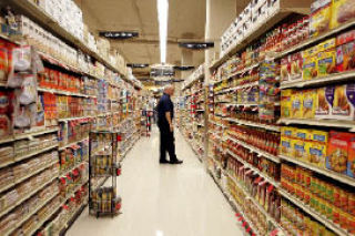 Safeway employee Bob Holloway checks the perfectly lined shelves prior to the grand opening of the new store in the Avalon apartment complex.