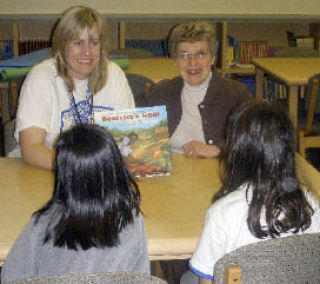 Librarian Kristine McLane (left) and Jubilee volunteer Tina Freed introduce the Read to Feed program to students at Lake Hills Elementary School.