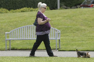 Natalie Brahs takes her dog Joe Joe for a walk at Crossroads Park on a cloudy