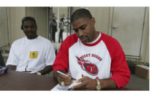 Former NFL player Chris Hayes signs his book at the Puget Sound Titans ‘Junior Day’ at Newport High School on Saturday