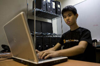 Ed Jiang checks something on his computer at his summer job with VoiceBox Technologies Inc. in Bellevue.