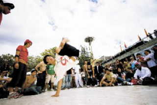 A breakdancer shows off his moves in the Seattle Center during last year’s Bumbershoot music and arts festival. The event – which features live music
