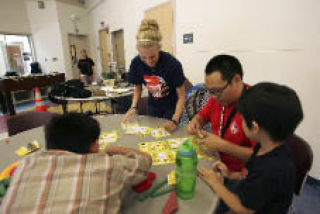 Volunteers Haley Rutledge and Daniel Nguyen play with kids Thursday