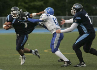 Interlake’s Brett Kirschner tries to get outside the grasp of Ingraham’s Tim Jones during the Saints 41-0 season-opening win on Friday.