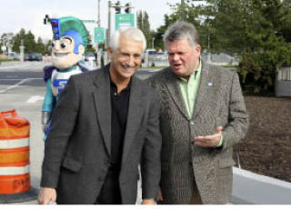 U.S. Rep. Dave Reichert and Seattle Mayor Greg Nickels talk during an Oct. 9 ribbon-cutting ceremony that marked the completion of a new westbound HOV lane between Bellevue and Mercer Island. In the background is the Sound Transit mascot