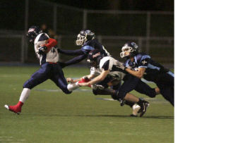 Juanita’s Robert Golden runs past Interlake defenders Matt Mawangi