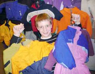 Rick Teegarden basks in a smattering of the 55 children’s coats that he donated to Encompass this winter as part of a five-year drive in which the Sammamish High School junior has collected and distributed more than 5