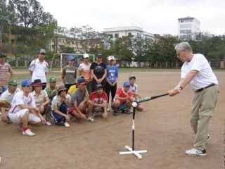 Medina resident and long-time baseball coach Phil Rognier demonstrates hitting a ball off the tee during his 16-day trip to Vietnam.