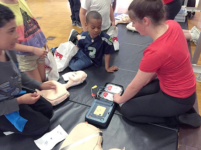 Taylor Kelley demonstrates how to use a defibrillator.