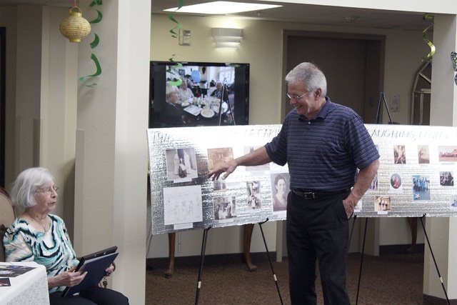 Ellen Gerlitz listens to son Jim Gerlitz explain her life to a crowd at The Garden Club in Bellevue at her 100th birthday celebration.