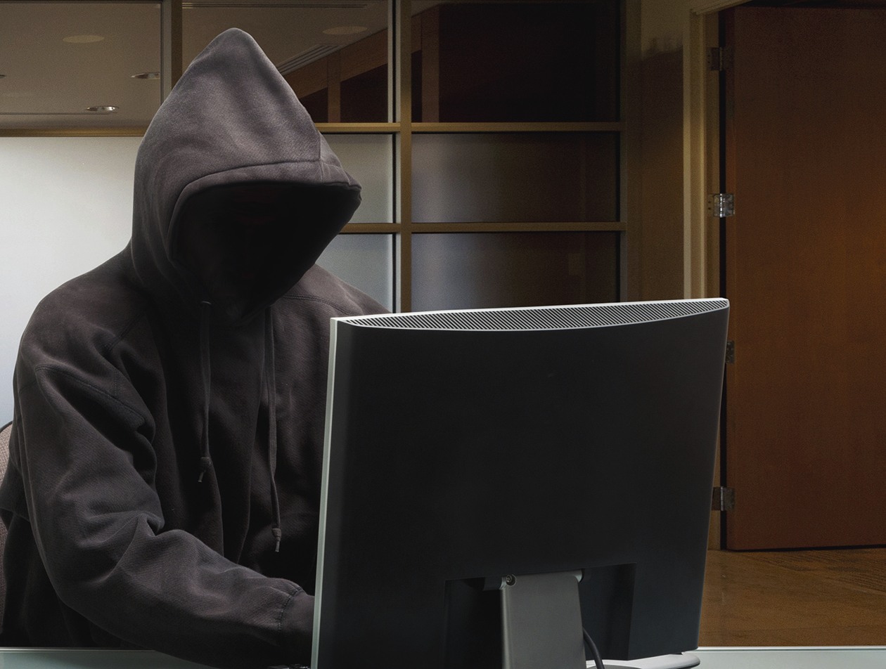 Caucasian man in hoody sitting at office desk